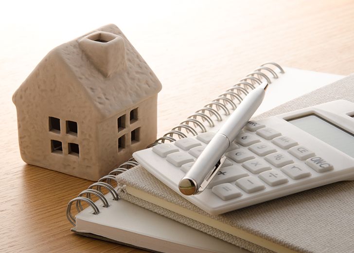 close-up of house and calculator with notebook