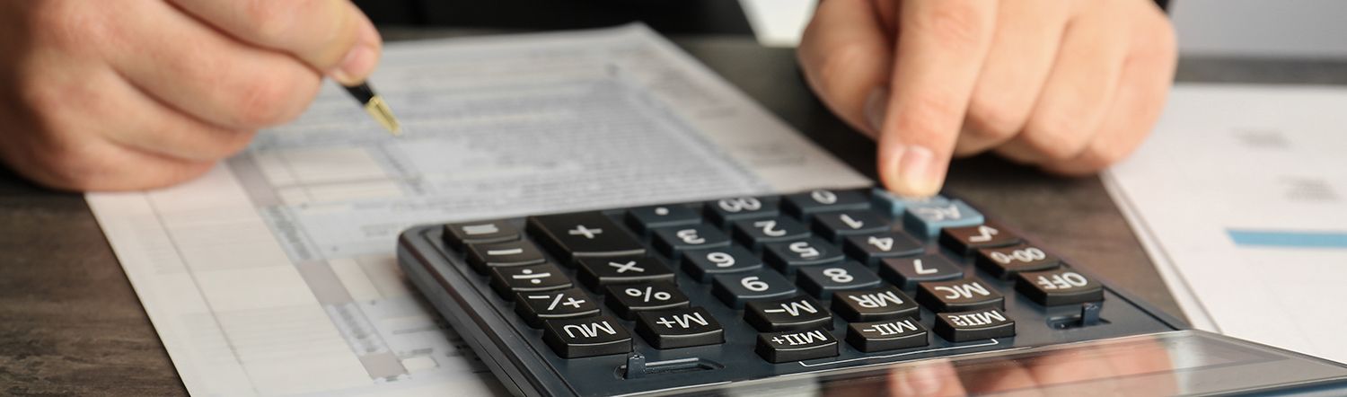 close-up of gentleman typing on calculator