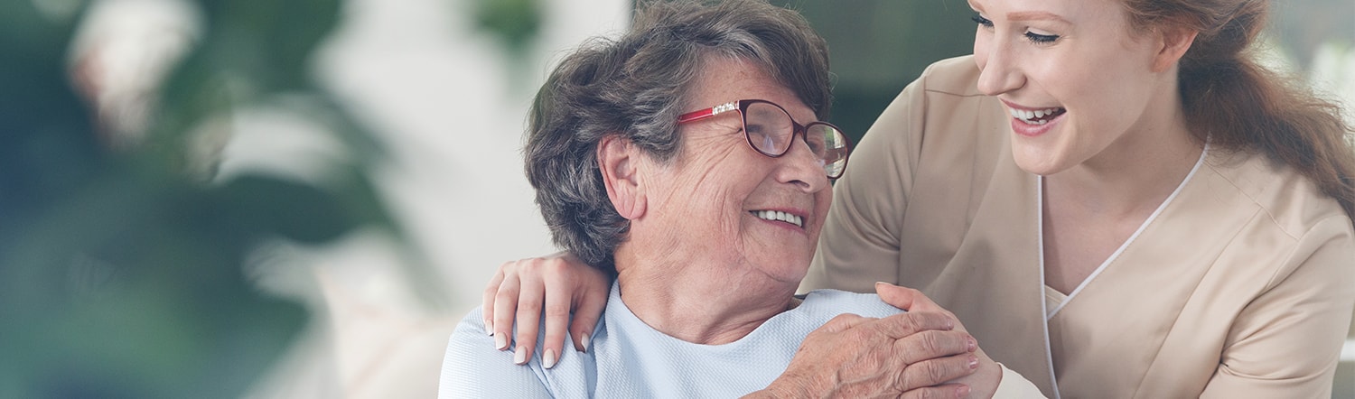 close-up of nurse aid smiling with elderly woman