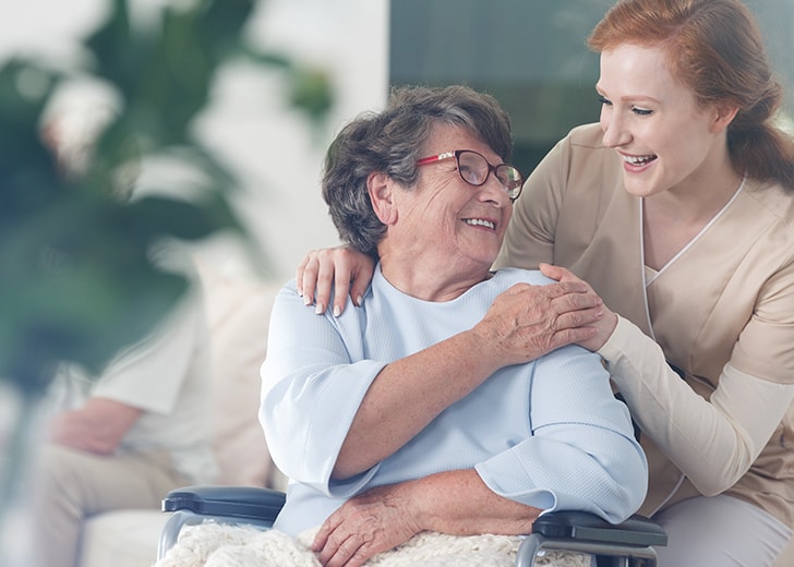 nurse aid smiling with elderly woman