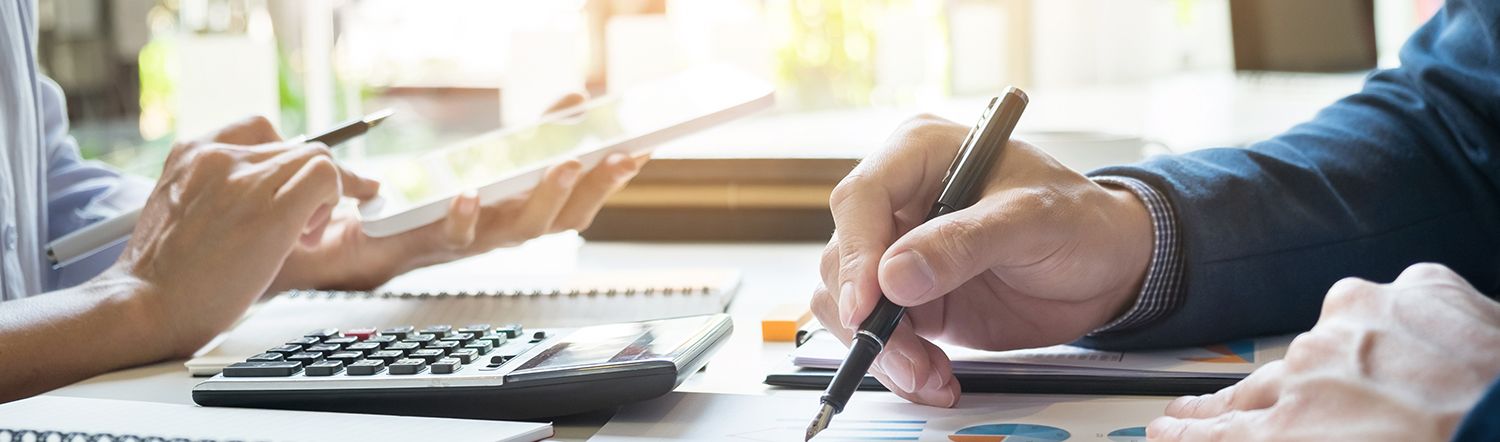 close-up of gentleman writing and looking over graphs