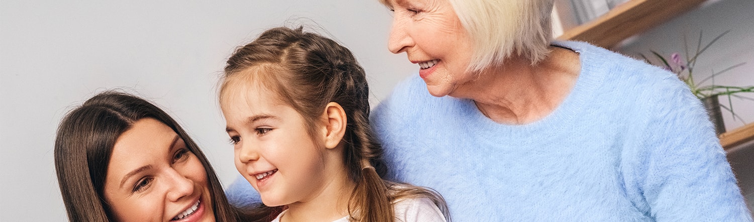 grandma, mother, and little girl smiling