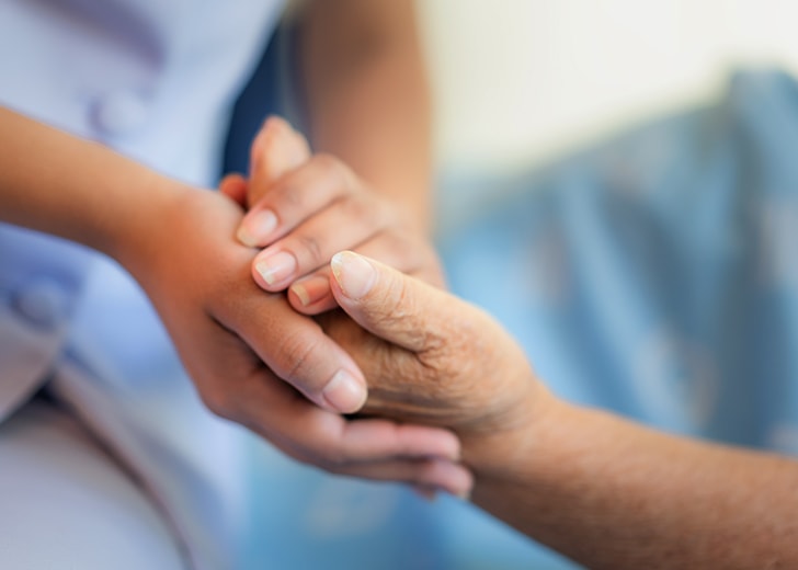 nurse holding elderly woman hands