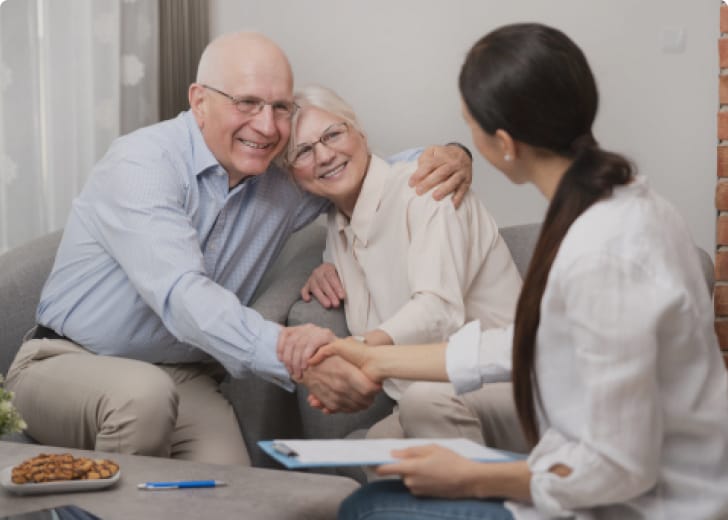 young lady and elderly man shaking hands