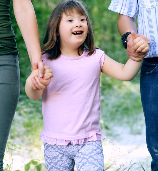 parents holding special needs girls hands