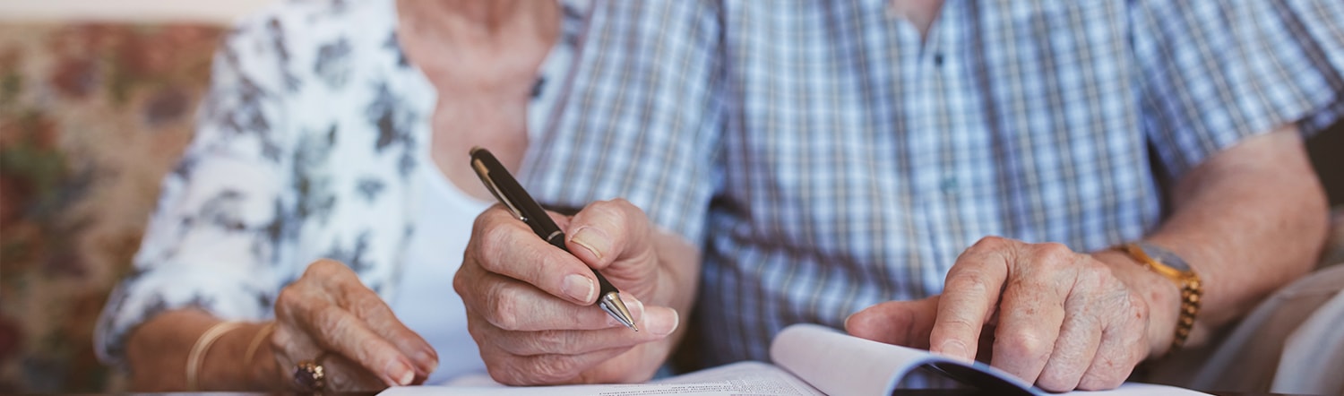 close-up of elderly couple writing will