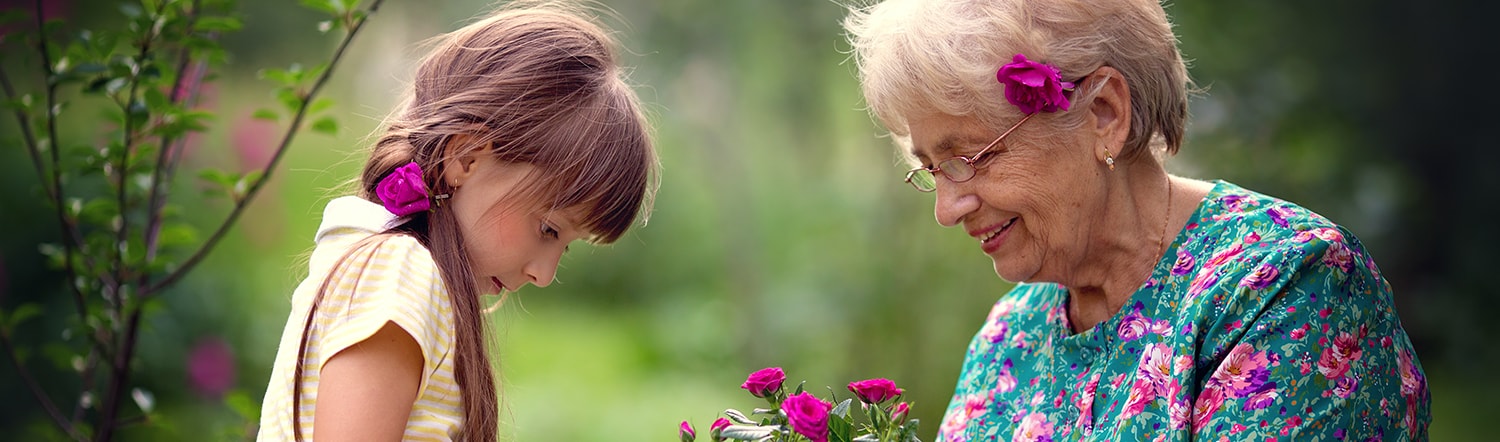 close-up of grandmother and granddaughter planting flowers