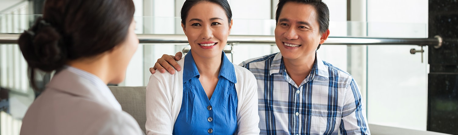 close-up of happy couple talking to real estate agent