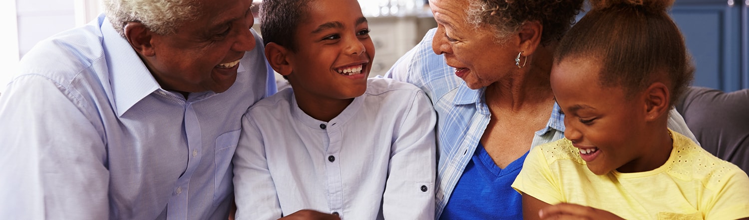 close-up of grandparents smiling and laughing with their grand kids