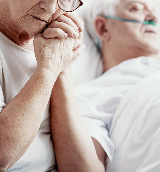 wife holding sick husbands hand