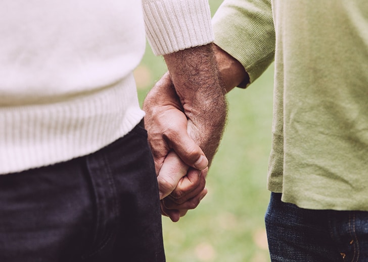 close-up of elderly couple holding hands
