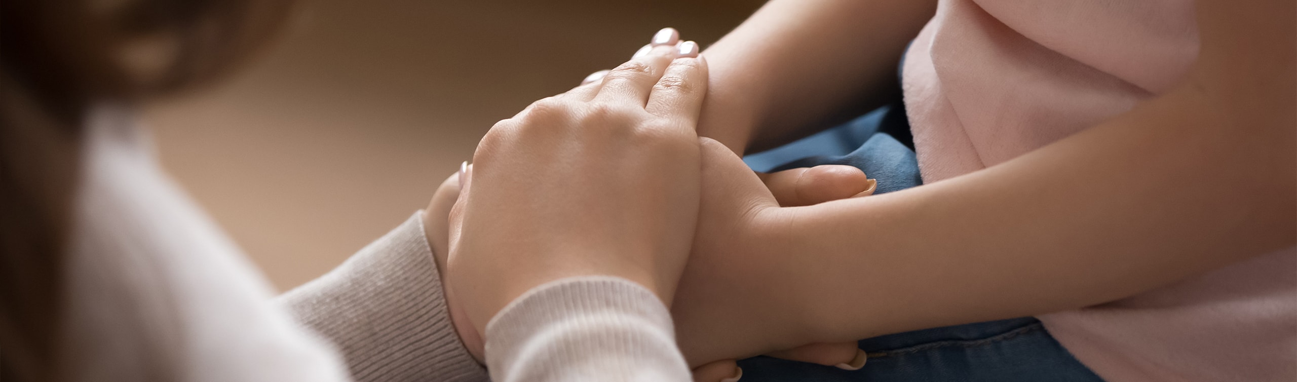 legal guardian comforts child by holding hands