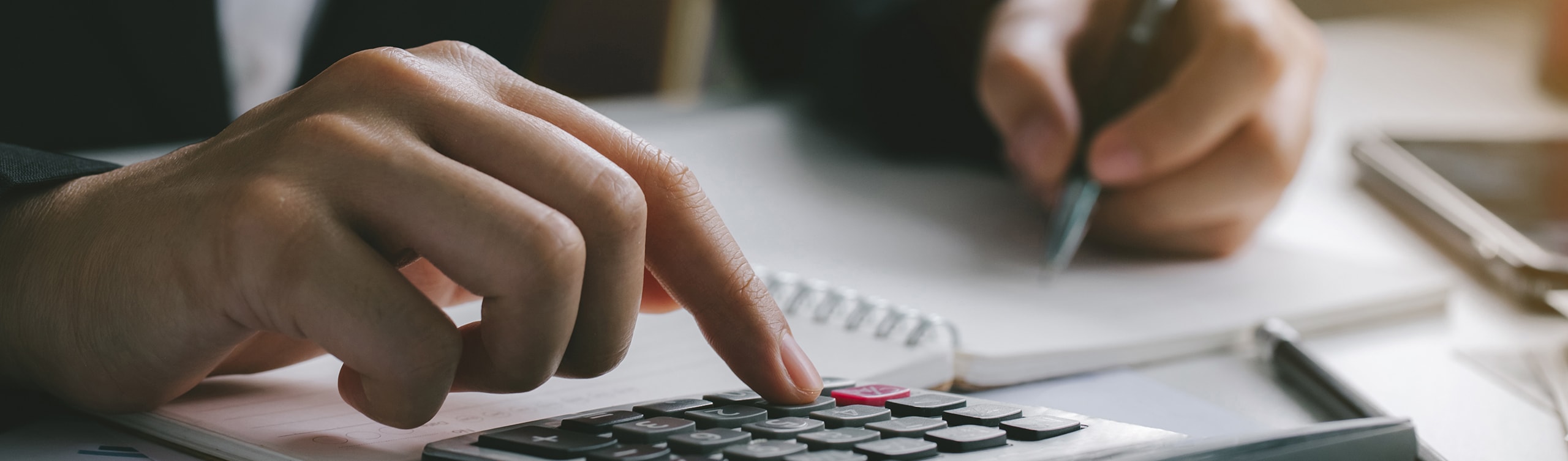 up close of gentleman typing on calculator