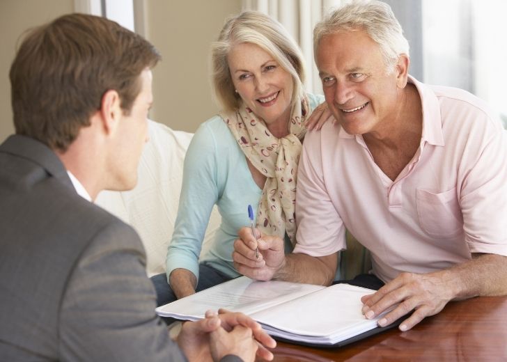 couple looks over estate planning documents with lawyer